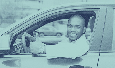 African American man in car giving thumbs up