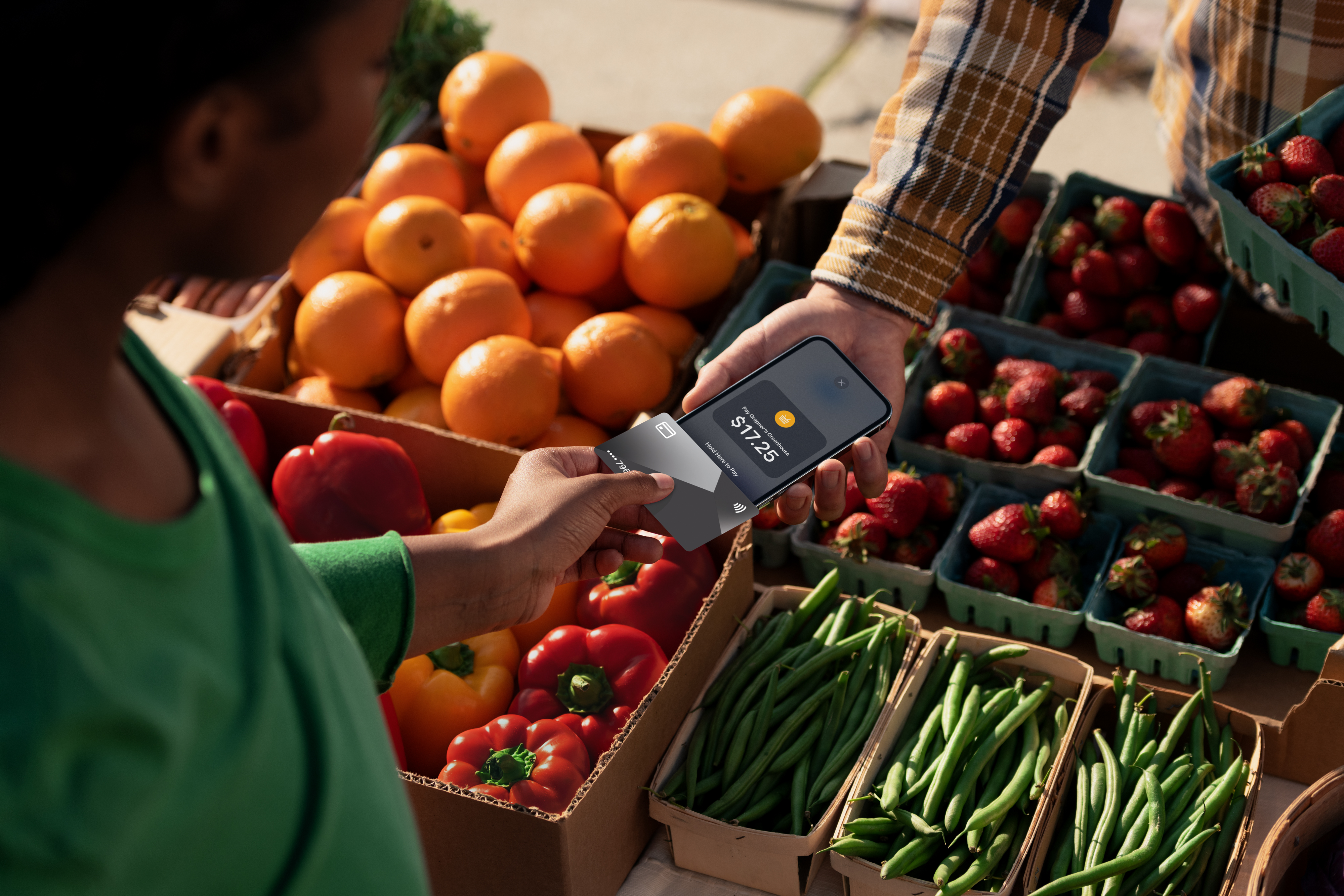 Person shopping for produce paying using their card and vendor's iPhone.