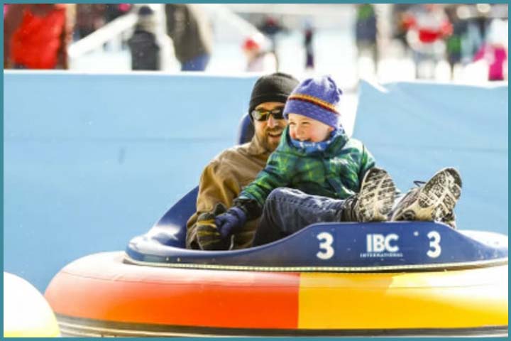Father and son enjoying ride on ice bumper cars.