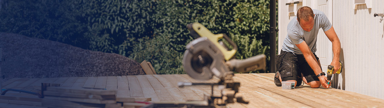 Man building deck in backyard.
