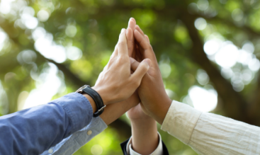 Four hands coming together in celebratory "high five"